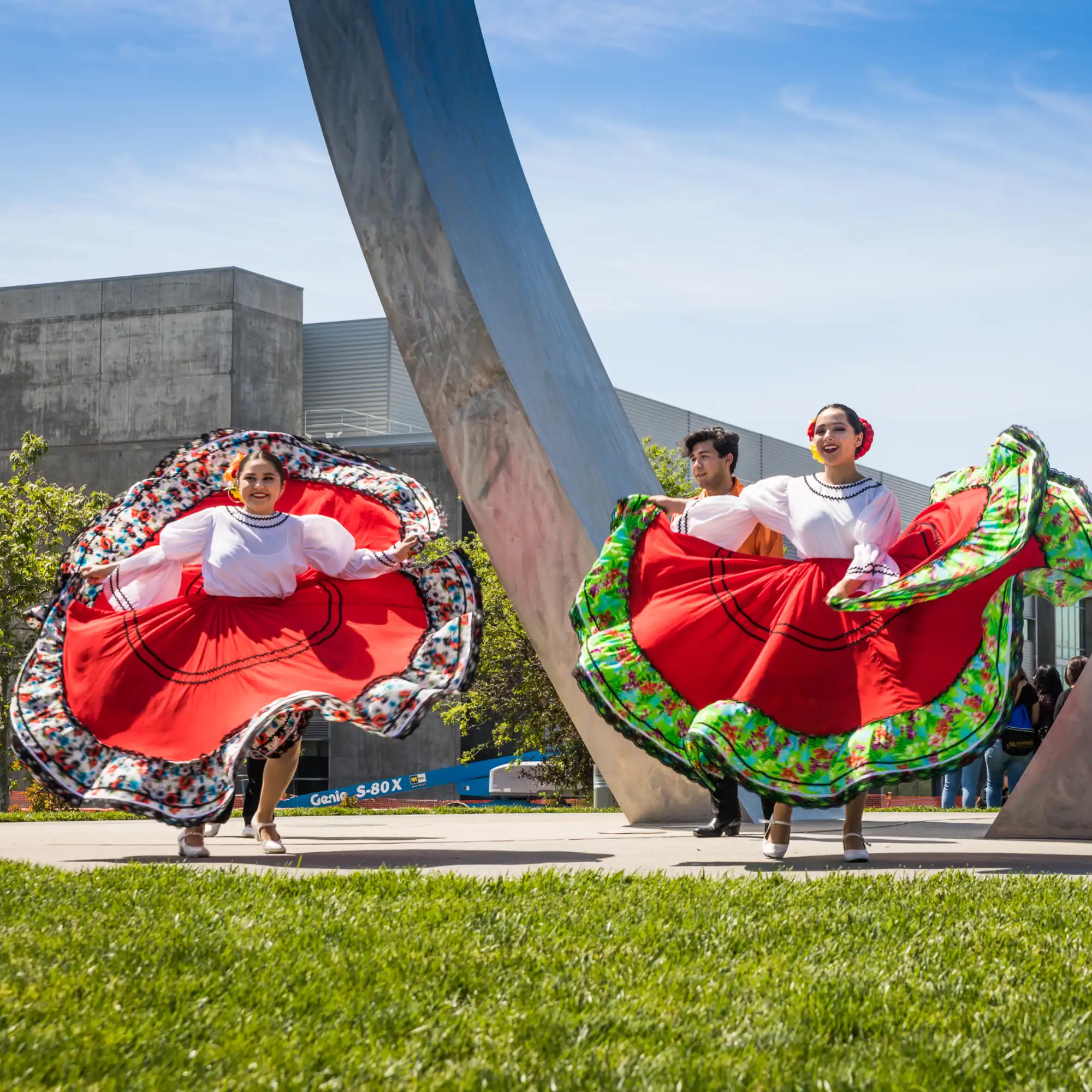 Ballet Folklorico de UC Merced dancing in front of the new beginnings statue.